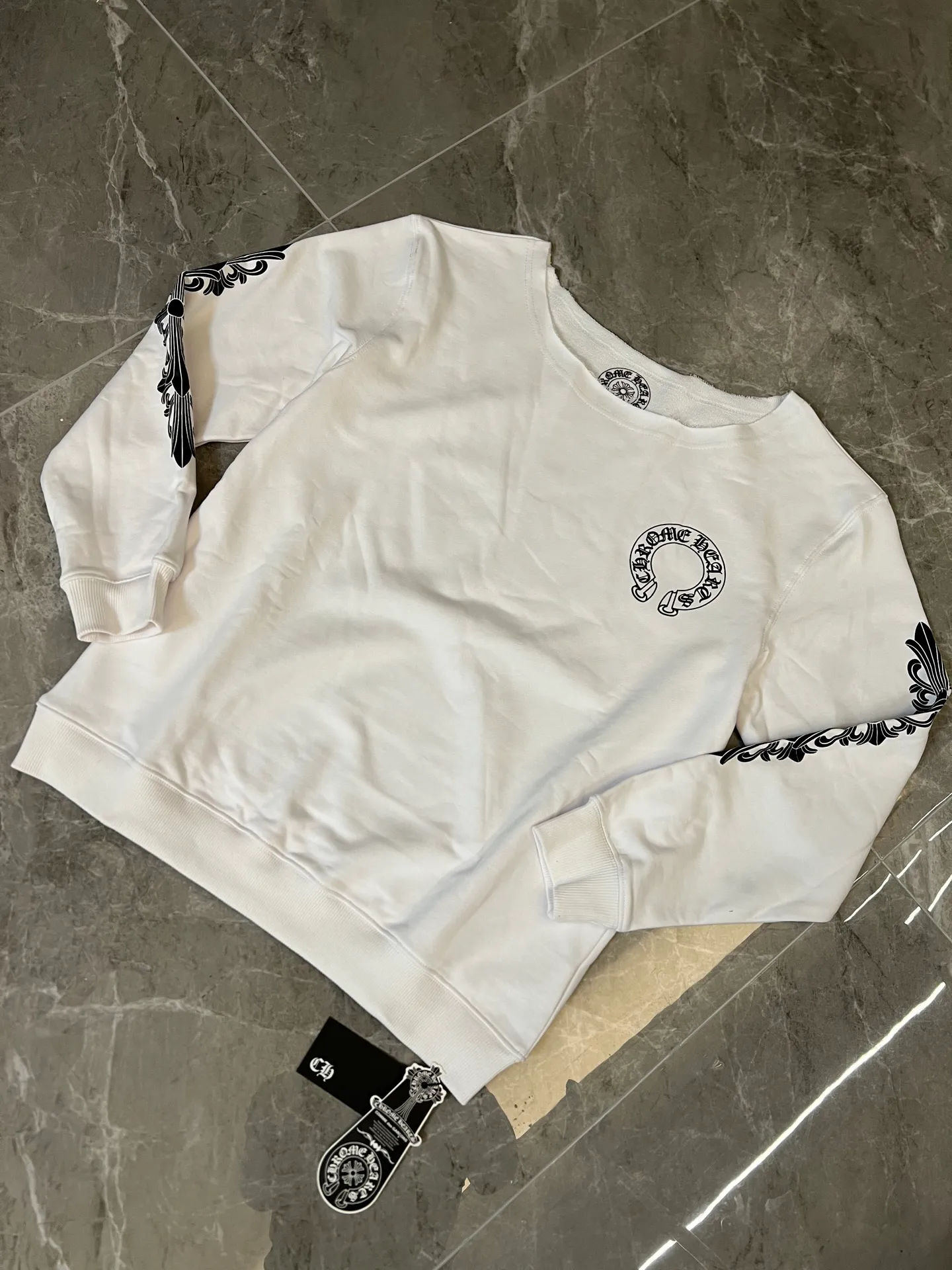 P186 [Next day] Chrome Hearts/Chrome Hearts 25ss CH Arm Cross Horseshoe Sanskrit Sloping Shoulder Sweatshirt (White - Women's Loose) Custom-woven fabric with a delicate and soft texture, gentle and non-prickly. The brand's Sanskrit inscriptions highlight the brand's unique American dark heavy industry trend style from all angles. It is fashionable and avant-garde. The unique OVEISIZE cut is more in line with the aesthetic style of the Z generation young people. It is an indispensable goddess wardrobe item!  Size: s m l. Available in seconds. Detailed sizes can be found in Figure 9.